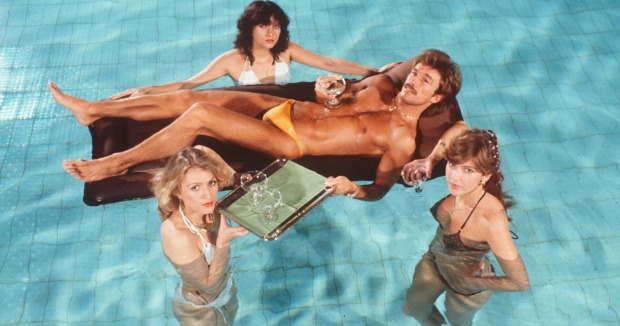 Der junge Boxer René Weller liegt, von drei attraktiven Frauen, die ihm Champagner servieren umgeben, auf einer Luftmatratze in einem Pool
