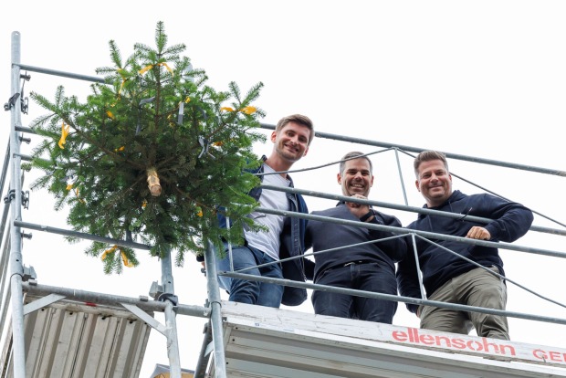 Der traditionelle Firstbaum auf dem Dach der fertigten Rohbauten am Garnmarkt Ost in Götzis.