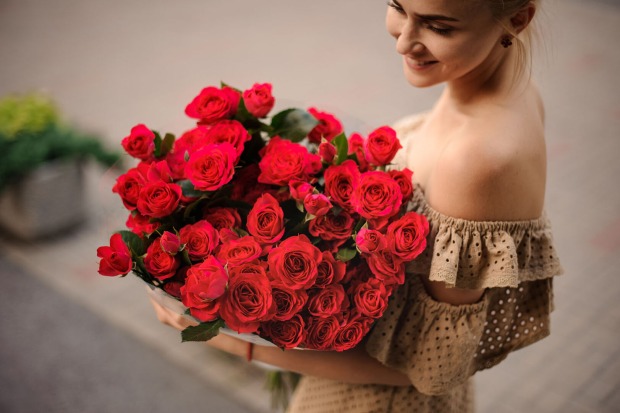 Frau mit roten Rosen | Credit: iStock.com/MaximFesenko