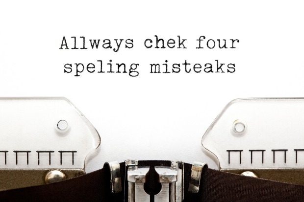 Nahaufnahme eines in eine Schreibmaschine eingespannte Blattes Papier, auf dem der Satz "Allways chek four speling misteaks" steht