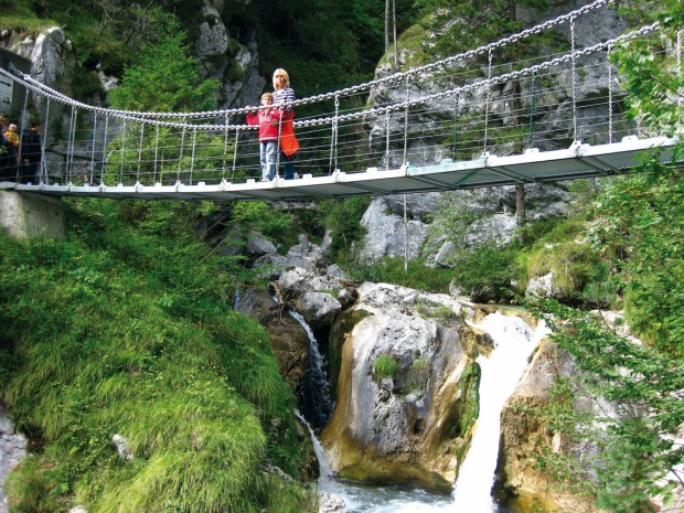 Eine Frau mit Kind auf der Hängebrücke in der Tscheppaschlucht
