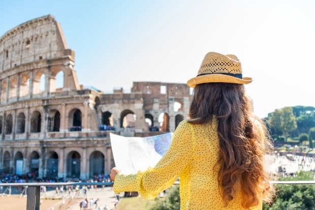 Frau steht vor dem Kolosseum in Rom | Credit: iStock.com/CentralITAlliance