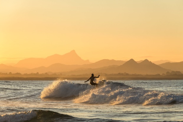 Surfer auf einer Welle | Credit: iStock.com/RugliG