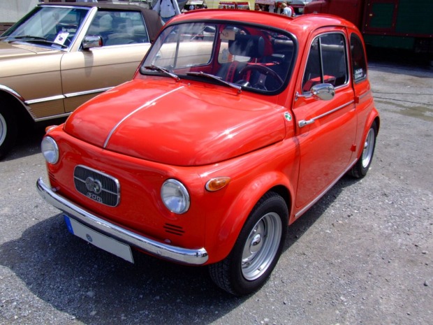 Ein roter Puch 500 steht auch einem Parkplatz