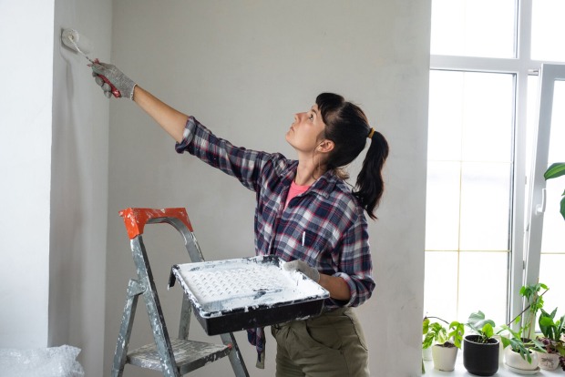 Frau streicht ihre Wohnung | Credit: iStock.com/Ольга Симонова