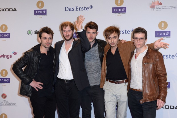 Die Band Wanda auf dem roten Teppich in alter Besetzung. Sie tragen schwarze und braune Jacken.