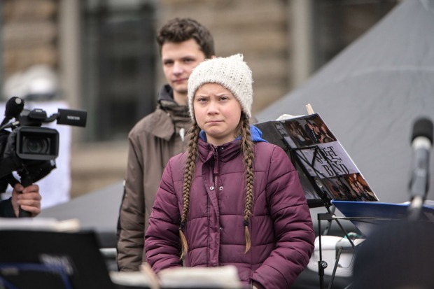 Greta Thunberg, die von einem Rednerpult aus auf ihr Publikum blickt