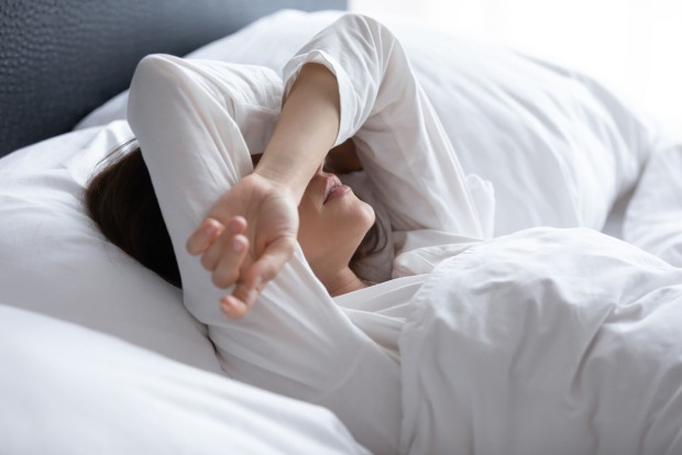 Frau liegt im Bett | Credit: iStock.com/fizkes