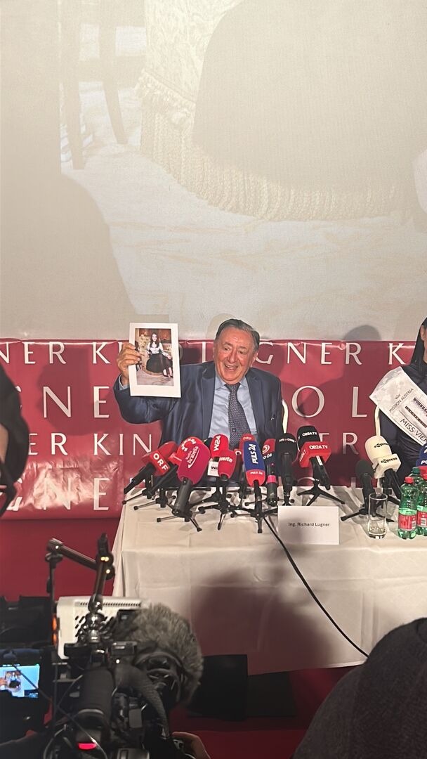 Richard Lugner hält bei der Pressekonferenz das Foto von Priscilla Presley vor die Kamera.