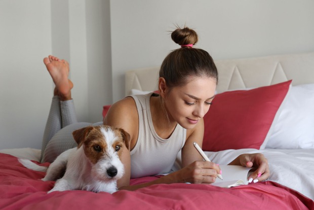 Frau schreibt in ihr Tagebuch | Credit: iStock.com/Evrymmnt