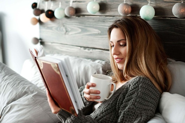 Frau liest Buch im Bett | Credit: iStock.com/gpointstudio