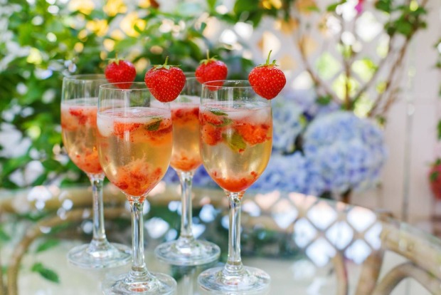 Gläser gefüllt mit Prosecco und Erdbeerpüree, dekoriert mit einer frischen Erdbeere