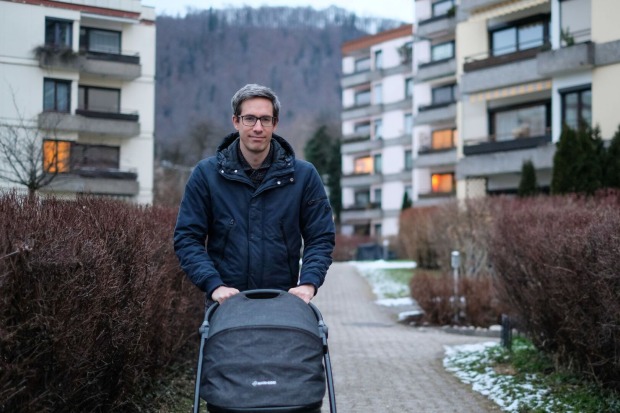Kay-Michael Dankl (KPÖ Plus) geht mit dem Kinderwagen und seiner Tochter darin durch eine Siedlung spazieren.