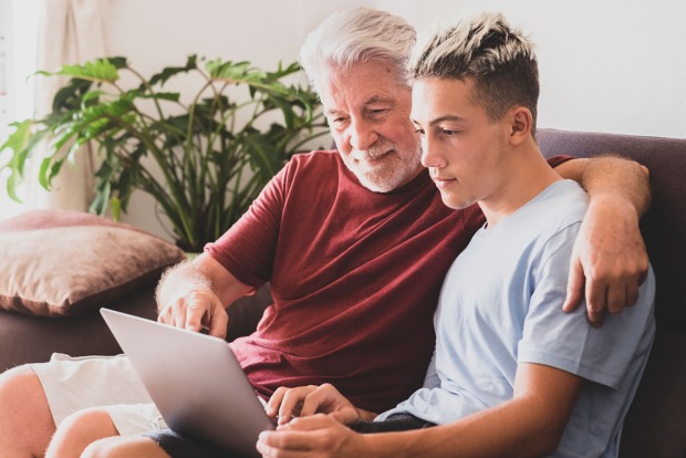 Opa und Enkel sitzen auf der Couch | Credit: iStock.com/lucigerma