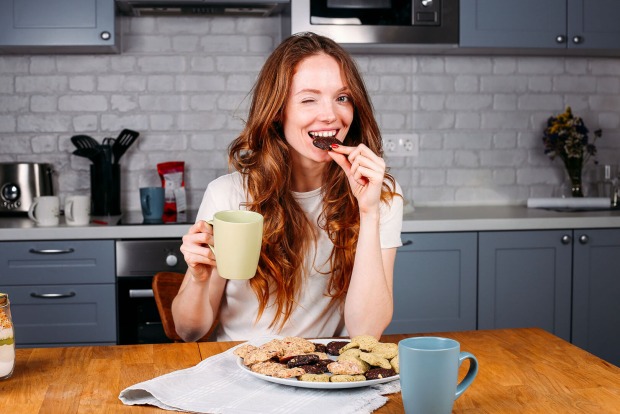 Frau trinkt Kaffee und isst Schokolade | Credit: iStock.com/Iuliia Bondar