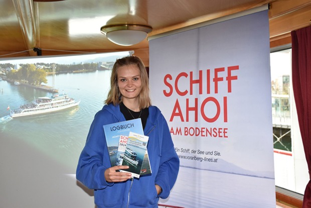 Bianca Kaufmann (Vorarlberg Lines Praktikantin) mit druckfrischen "Logbuch"-Magazin und dem neuen 76seitigen Schiff Ahoi!-Programmfolder.