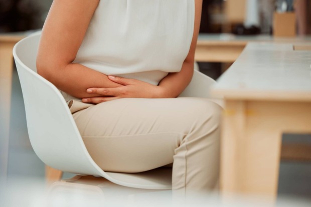 Detailansicht des Oberkörpers einer Frau, die ihren Bauch abstützt