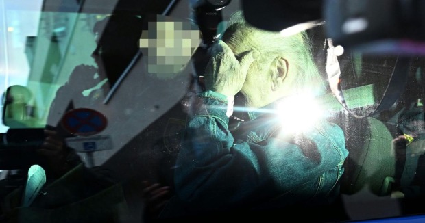 Josef Fritzl verdeckt im Auto mit der Hand sein Gesicht.