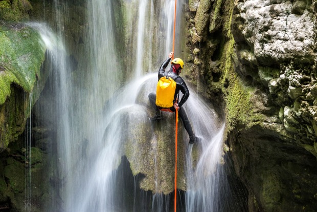 Ein Mann hängt an einem Seil in einer Schlucht.
