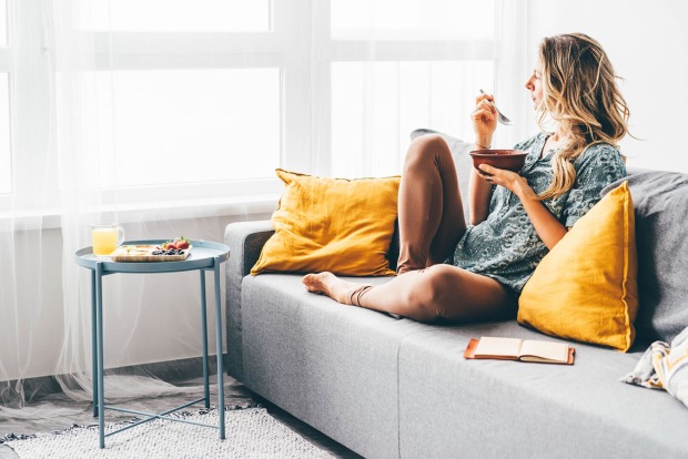 Frau sitzt gemütlich auf der Couch | Credit: iStock.com/Maria Korneeva