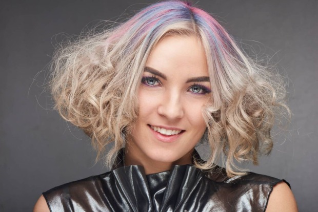 Attraktive Frau mit blonden Haaren mit bunten Strähnchen und hellen Augen
