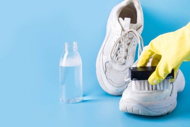 Weiße Schuhe, die gerade mit einem Bürstchen gereinigt werden.