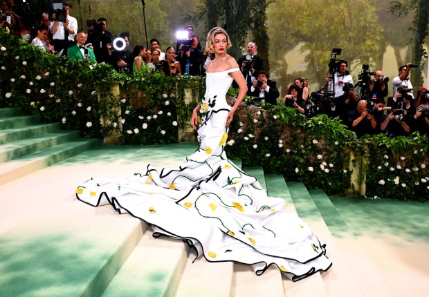 Eine blonde Frau in einem weißen Kleid mit Blumen-Applikationen
