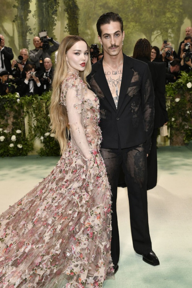 Eine Frau in einem Blumen-Kleid neben einem Mann in einem schwarzen Anzug