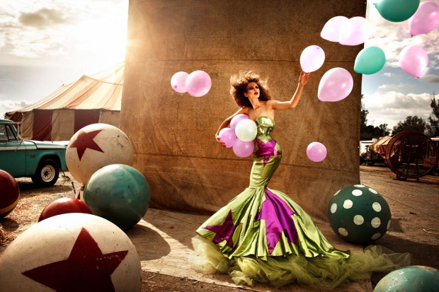 Eine Frau in einem grünen Kleid ist umgeben von Luftballons