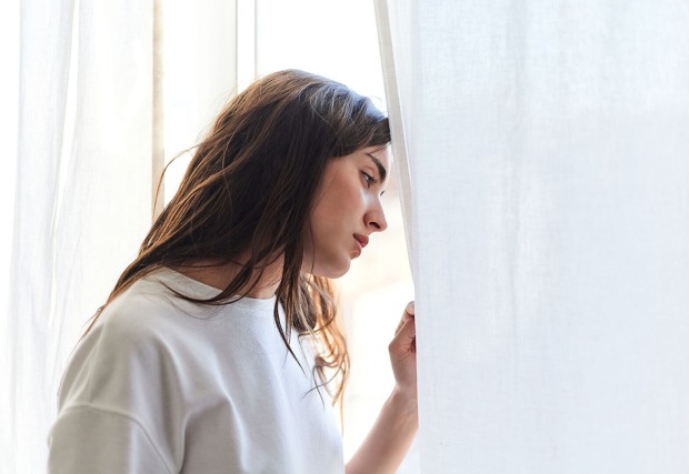 Frau schaut nachdenklich aus einem Fenster | Credit: iStock.com/Javi Sanz