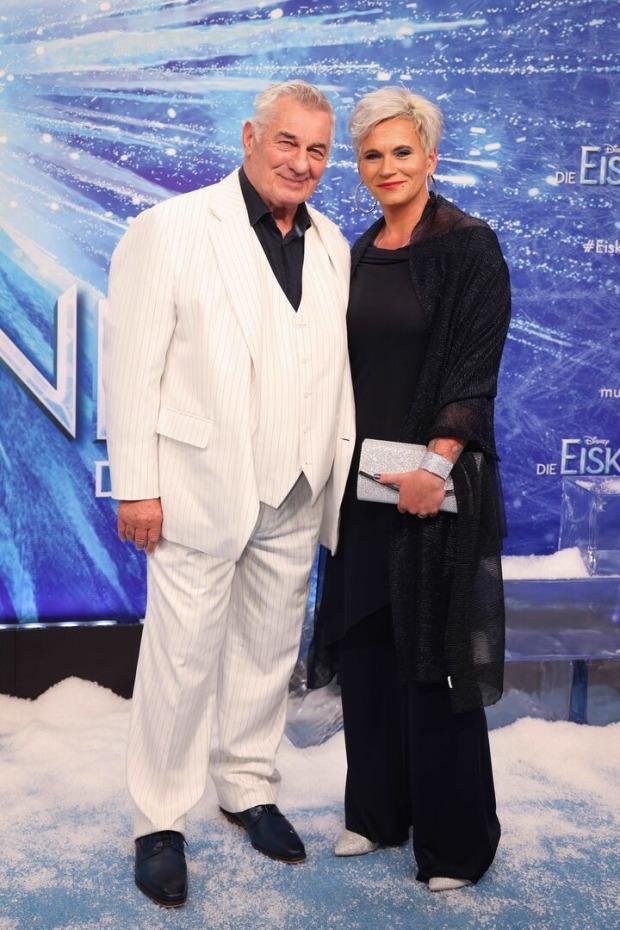 Heinz Hoenig und Annika Kärsten Hoenig bei einer Premiere. Er trägt weiß und sie schwarz.