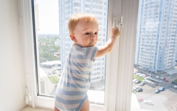 Baby steht am Fenster | Credit: iStock.com/Artfoliophoto