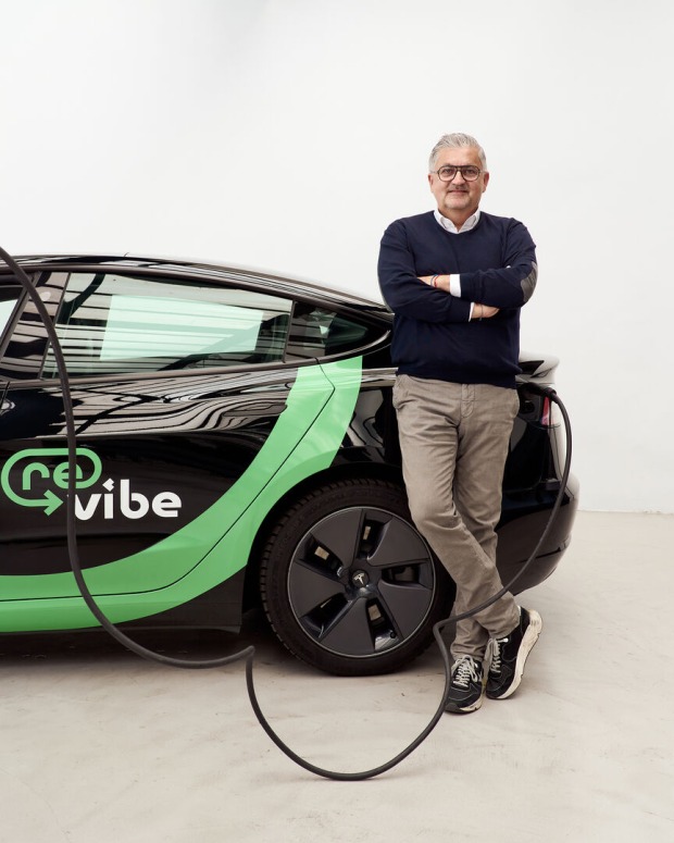 Porträt, an einem gebrandeten Auto lehnend