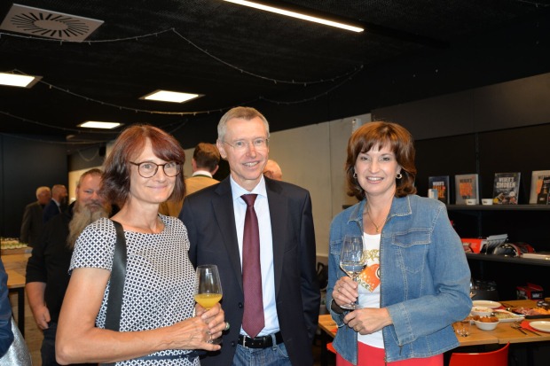 Zwei Frauen und ein Mann blicken in die Kamera