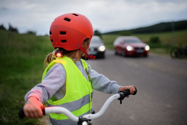 Ein Kind mit Fahrrad, Helm und Warnweste.