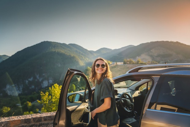 Frau steigt aus Auto aus | Credit: iStock.com/Olezzo