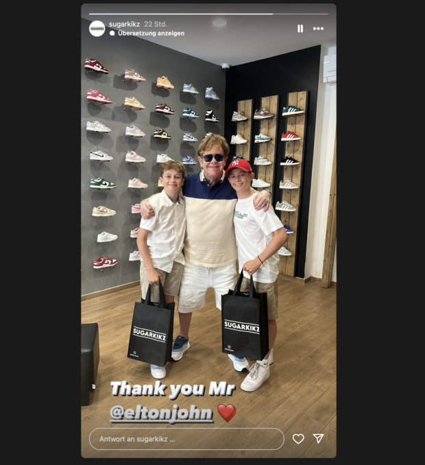 Ein älterer Mann steht zwischen zwei jungen Burschen