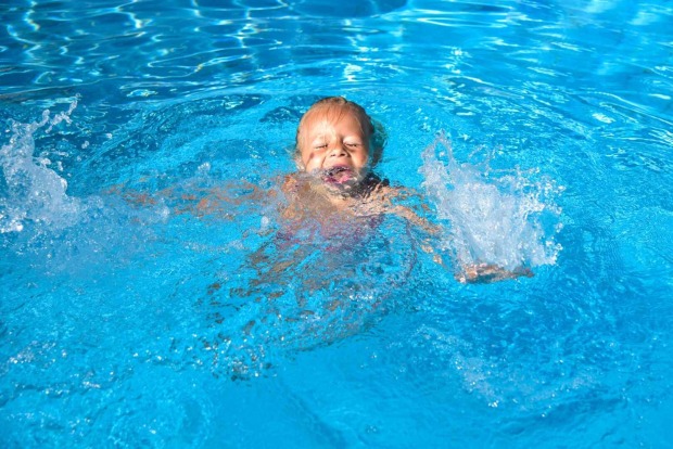 Ein Kind droht in einem Schwimmbecken zu ertrinken.
