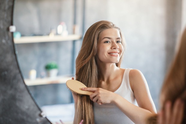 Frau bürstet ihre Haare | Credit: iStock.com/Prostock-Studio