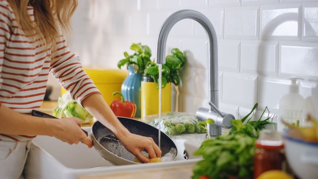 Frau spült Pfanne per Hand ab | Credit: iStock.com/gorodenkoff