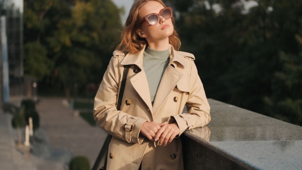 Frau trägt einen Trenchcoat | Credit: iStock.com/Garetsworkshop