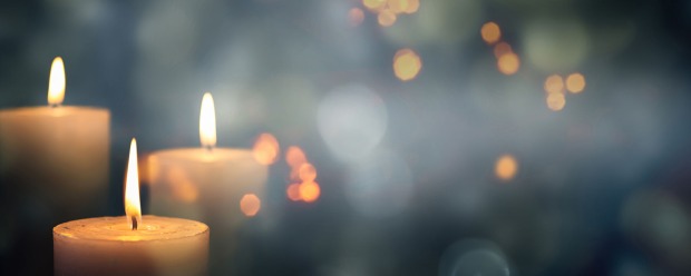 Brennende Kerzen im Gedenken an einen geliebten Menschen | Credit: iStock.com/winyuu