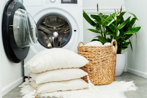 Kissen liegen vor Waschmaschine | Credit: iStock.com/Damian Lugowski