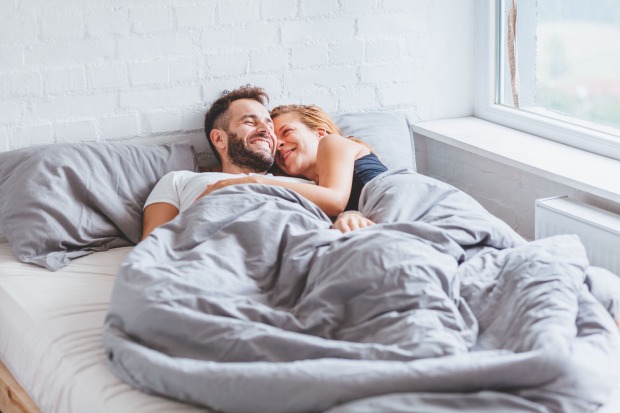 Pärchen kuschelt im Bett