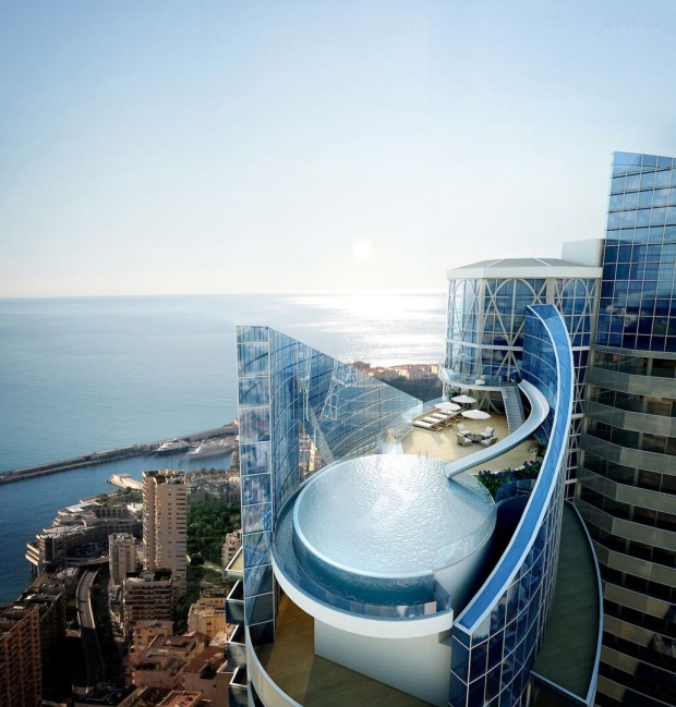 Pool mit Rutsche auf Hochhaus, dahinter Meer