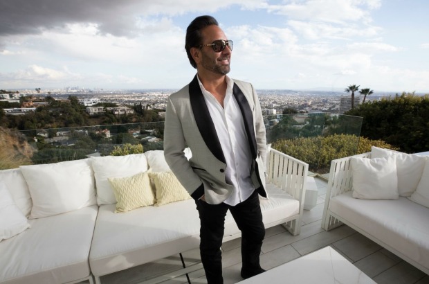 Mann auf Terrasse, dahinter Sofas und Landschaft