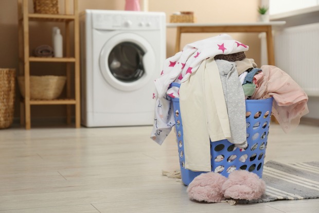 Wäschekorb steht vor Waschmaschine | Credit: iStock.com/Liudmila Chernetska