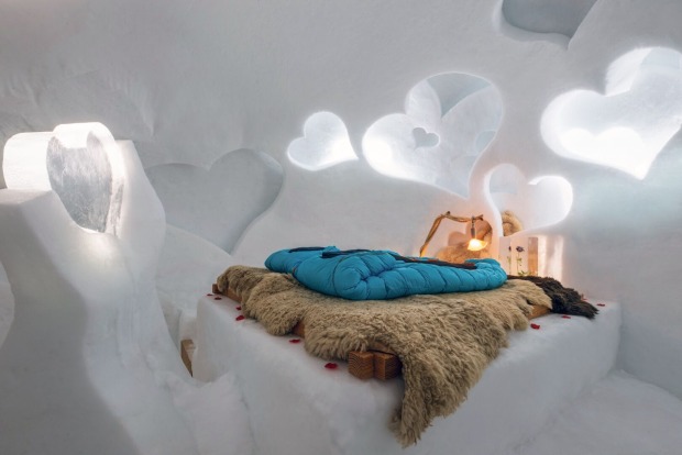 Doppelbett mit Fell und Schlafsack in einem Iglu mit Herzen