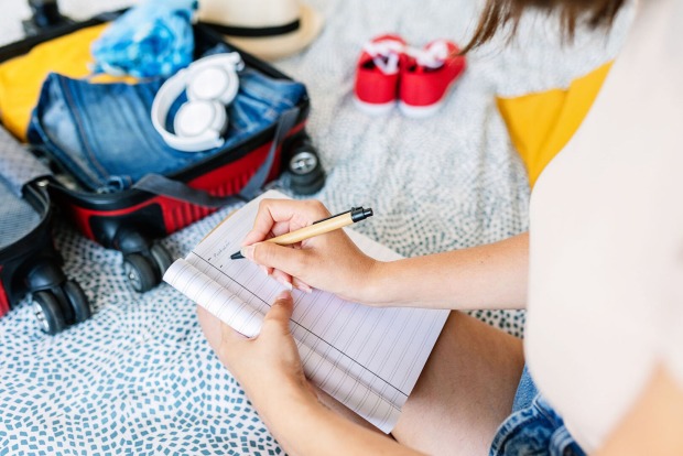 Frau packt Handgepäck | Credit: iStock.com/Xavier Lorenzo