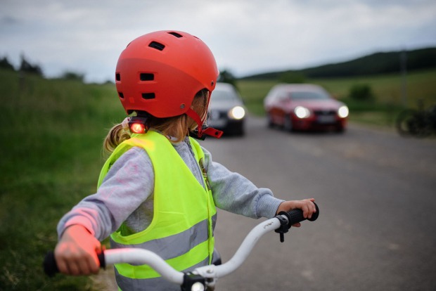 Kind mit Warnweste auf Fahrrad | Credit: iStock.com/Halfpoint